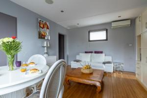 a living room with a white table and chairs at Lumineux - parking - wifi - clim - 3 lits dont 1 King size - jardin- in Mont-de-Marsan +10 photos