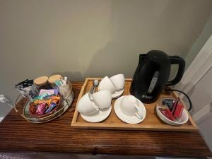 a wooden table with plates and a coffee maker on it at Castletown Carlow in Carlow