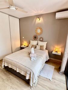 a bedroom with a bed with a stuffed animal on it at Cosy Sand plages et nature in Étang-Salé