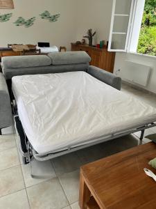 een bed in een kamer met een bank en een tafel bij Villa les Mésanges 5 min from the beaches in Vaux-sur-Mer
