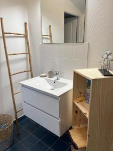 een badkamer met een wastafel en een spiegel bij Villa les Mésanges 5 min from the beaches in Vaux-sur-Mer