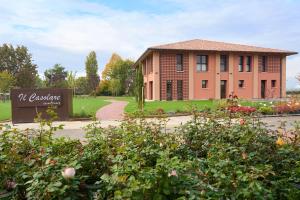 un edificio con un cartel frente a un jardín en Il Casolare Punto Fiore, en Castel San Pietro Terme