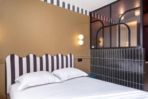 a bedroom with a bed with a striped headboard at Studio Élégant-Une Escapade Raffinée en Plein Cœur de la Ville in Lyon