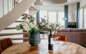 a bottle of wine on a table with a vase of flowers at Flat Fish in Egmond aan Zee