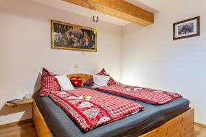 Un dormitorio con una cama con almohadas rojas y blancas. en Ferienwohnung Brandenkopf, en Oberharmersbach