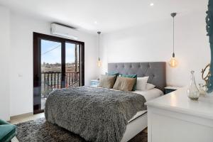 ein weißes Schlafzimmer mit Bett und Balkon in der Unterkunft Casa El Molino in Yaiza + 21 Fotos