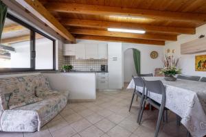 a kitchen and living room with a table and a couch at Casa Silvia in Calasetta