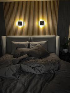 a bed in a room with two lights on the wall at Villa Lakstīgalas Lux in Skrīveri