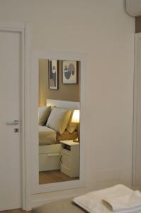 a mirror reflecting a bedroom with a bed in a room at La Terrazza di Luca in Tavernelle