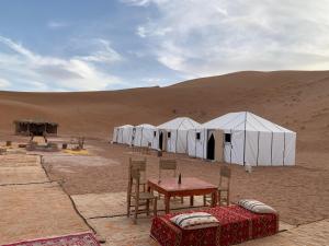 a group of white tents in the desert at Camp atlantic chegaga in Mhamid +51 photos