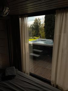 a room with a large window with a tub outside at Villa Lakstīgalas Lux in Skrīveri +62 photos