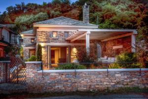 a brick house with a stone wall at Sunrise Pelion Sea View Villas in Chorefto