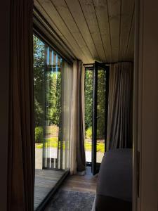a bedroom with a large glass door to a porch at Villa Lakstīgalas Lux in Skrīveri +62 photos