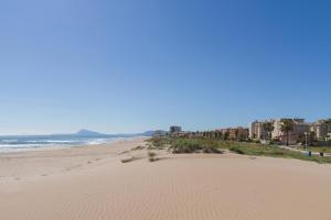 a sandy beach with buildings and the ocean at Ca Llaurí in Daimuz