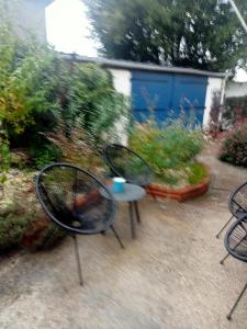 two chairs and a table in a garden at Chambre pour une personne in Blois