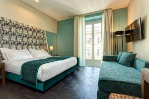 ローマにあるMascagni Luxury Rooms & Suitesのベッドとソファ付きのホテルルーム