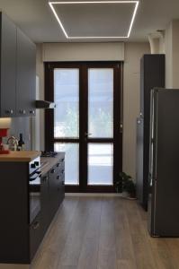 a kitchen with black appliances and a large window at La Terrazza di Luca B&B in Tavernelle