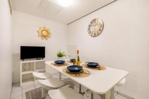 a white dining room with a white table and chairs at Relax Backnang Apartment in Backnang