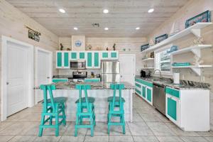 una cocina con encimeras y taburetes azules y blancos en Feelin' Tip-Sea, en Mustang Beach
