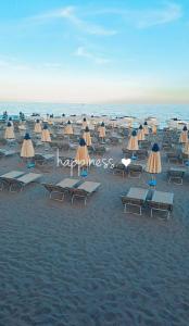 a bunch of chairs and umbrellas on a beach at Raggio di Sole in Loano