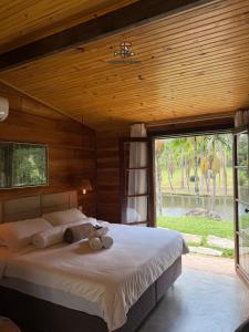 アイウルオカにあるPOUSADA PARAISO DOS TUCANOSの大きなベッドと大きな窓のある寝室