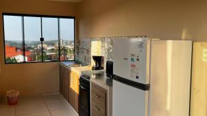 Apart 2 habitaciones vista a Itaipú - 32 في سيوداد ديل إستي: مطبخ مع ثلاجة بيضاء ونافذة +6 صور