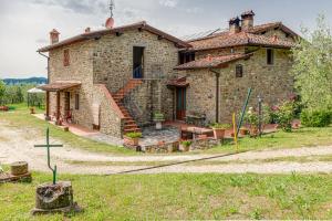 a stone house with a cross in front of it at Il Cerro La Capanna Piano Terra in Pelago