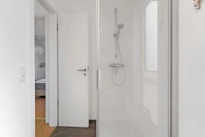 a bathroom with a shower with a glass door at Hausboot Sutje in Großenbrode +17 photos