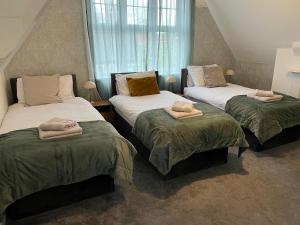 two beds with towels on them in a bedroom at Spacious 7-Bedroom Victorian House in Darlaston
