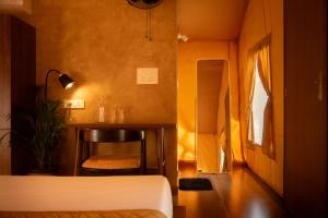 a bedroom with a bed and a table and a chair at Vanantara - Riverside Eco Retreat in Ernakulam +11 photos