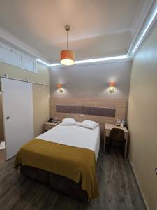 a bedroom with a large bed with a yellow blanket at Hotel de France in Brussels