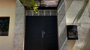 Apart 2 habitaciones vista a Itaipú - 32 في سيوداد ديل إستي: باب كراج أسود على مبنى من الطوب