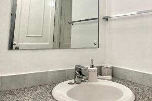 - un lavabo avec miroir et une bouteille de savon dans l'établissement 1 Bed Apartment Sleeps 4 with Free Parking, à Kingston