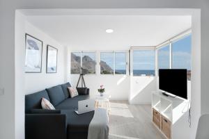 un soggiorno con un divano blu e una TV di Teresitas Beach By Aguita Salada a San Andrés