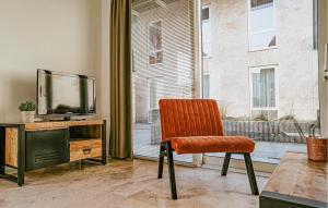 an orange chair in a room with a television at Sea Bass in Egmond aan Zee