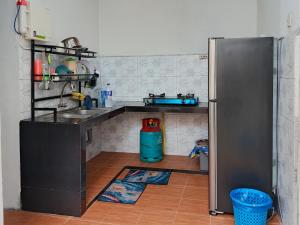 a kitchen with a sink and a refrigerator at RZ HOMESTAY With WiFi in Sungai Siput