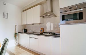 a kitchen with white cabinets and a stove top oven at Sea Bass in Egmond aan Zee