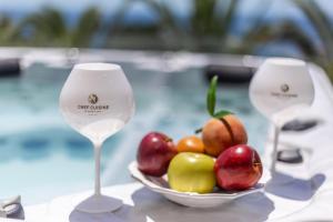 a bowl of fruit on a table with two wine glasses at Villa Chef Cuisine in Costa d'en Blanes