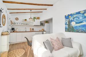 ein weißes Wohnzimmer mit einer weißen Couch und einer Küche in der Unterkunft Rincón De Tetuán in Árchez