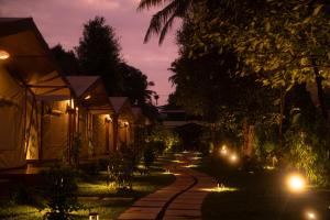 a pathway lit up at night with street lights at Vanantara - Riverside Eco Retreat in Ernakulam