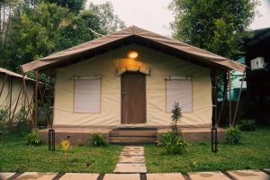 a small tent with a door in the grass at Vanantara - Riverside Eco Retreat in Ernakulam