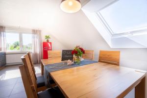 a dining room with a wooden table and chairs at Ferienwohnung Weitblick in Durbach +5 photos