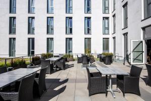 ハイデルベルクにあるPremier Inn Heidelberg City Centreの建物の前のテーブルと椅子のあるパティオ