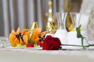 a table with a plate of fruit and a vase at Céu Palmas Hotel in Palmas