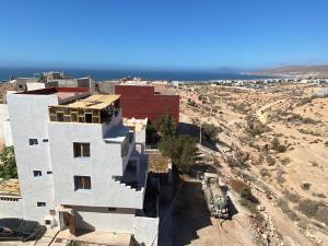 an aerial view of a white building with the ocean in the background at Red Carpet Surf Camp , Surf , Chill & Ocean Views in Tamraght in Tamraght Ouzdar
