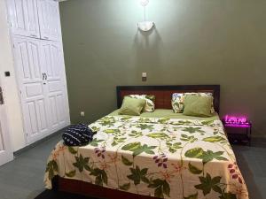 a bedroom with a bed with a green comforter at RBNB by MELUSH in Cotonou