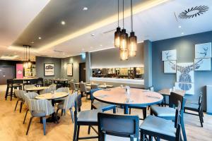 a restaurant with tables and chairs and a bar at Premier Inn Berlin City Süd in Berlin