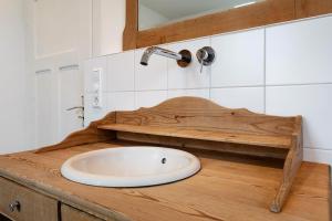 a bathroom with a white sink on a wooden counter at Ferienhaus am Künstleratelier in Riegel +22 photos