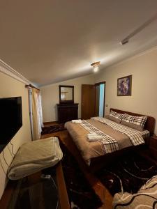 a bedroom with two beds and a flat screen tv at Twins in Korçë +17 photos