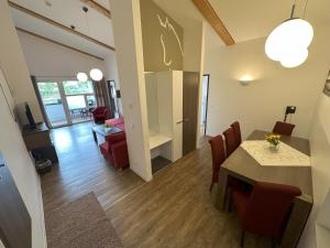 a room with a dining table and a living room at Reit- und Sporthotel Eibenstock in Eibenstock